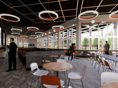 Modern cafeteria interior with round light fixtures, wooden tables, and white chairs. Several people are standing and sitting near large windows with views of greenery outside.