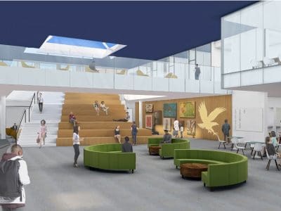 A modern, open lobby with green circular seating, wooden steps, wall art, people sitting and walking, and a glass balcony under a blue ceiling with a skylight.